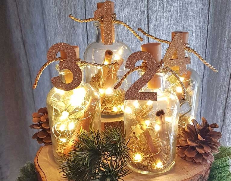 Origineller Adventskranz aus vier Flaschenvasen mit LED Flaschenlicht.
