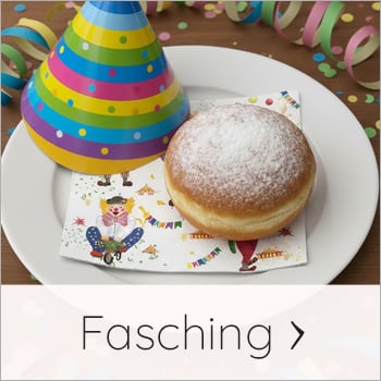 Dekorierter Teller mit bunter Clown Serviette, Krapfen und Partyhütchen für Fasching
