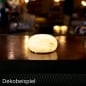 Duni LED-Tischlampe Alaea, kabellos und wiederaufladbar, modernes Design, auf Holztisch, warmes stimmungsvolles Licht.
