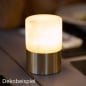 Duni LED-Tischlampe Fleur, kabellos und wiederaufladbar, modernes Design, auf Holztisch, warmes stimmungsvolles Licht.