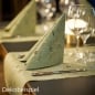 Gefaltete Premium-Serviette auf Tischläufer in Pistaziengrün aus der Weihnachtsserie Duni Noël Pistachio auf festlich gedecktem Tisch.