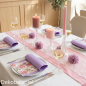 Romantische Tischdekoration in Rosa und Lila mit Spitzenläufer, prachtvollen Glas Kerzenhaltern und floral gemusterten Servietten.