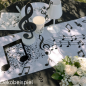 Dekobeispiel mit dem Vlies Tischläufer Noten, Musik in Weiß/Schwarz, 30 cm breit.
