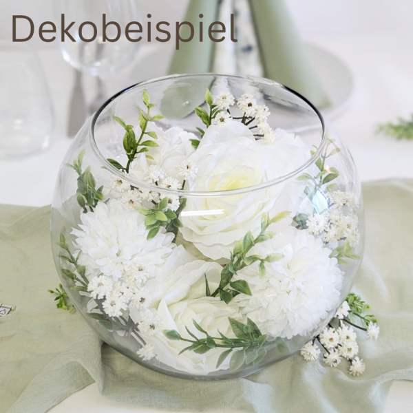 Stilvolle Kugel Glasvase gefüllt mit weißen Kunst Blumenköpfen und grünem Beiwerk auf einem zarten, mintgrünen Tischläufer.