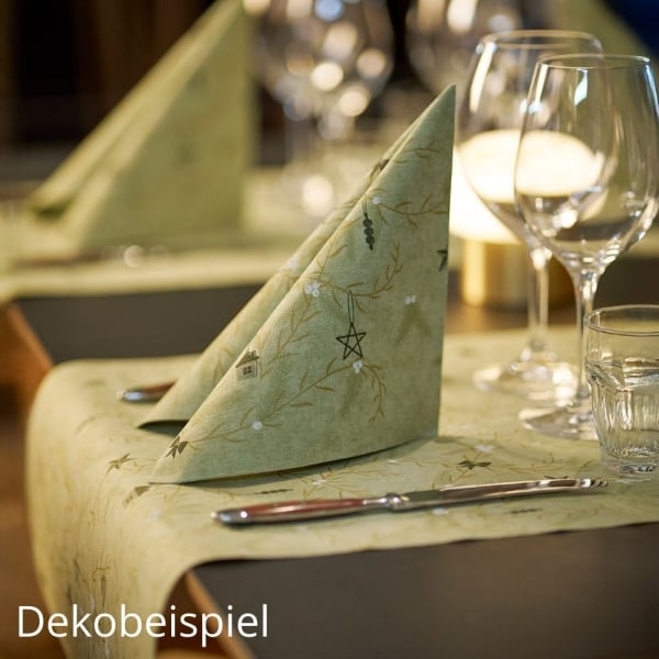 Gefaltete Premium-Serviette auf Tischläufer in Pistaziengrün aus der Weihnachtsserie Duni Noël Pistachio auf festlich gedecktem Tisch.