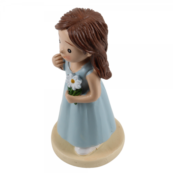 Niedliche Dekofigur eines lächelnden Mädchens im hellblauen Kleid mit einer weißen Blume.
