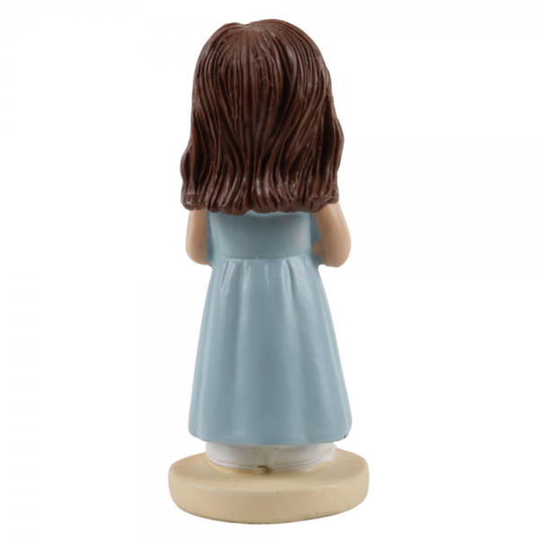 Rückansicht einer niedlichen Dekofigur Mädchens im hellblauen Kleid mit einer weißen Blume.