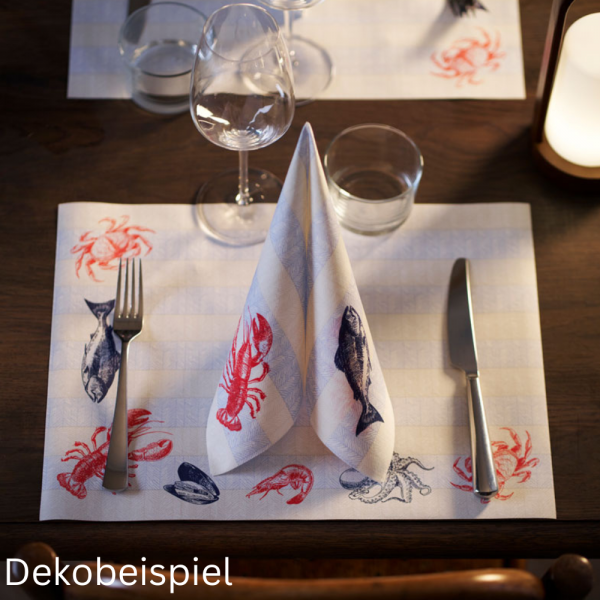 Duni Tischsets und Dunisoft Servietten gefaltet mit Meerestieren als Motiv auf einem Holz Tisch.