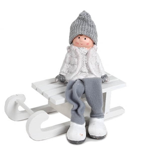 Kantenhocker Junge mit Strickmütze, Schlackerbeinen, Schlitten