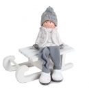 Kantenhocker Junge mit Strickmütze, Schlackerbeinen, Schlitten